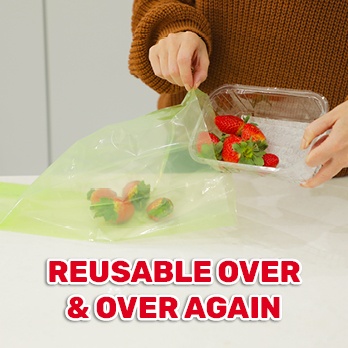 Person placing strawberries in a Fresher For Longer Bag that can be reused over & over again.