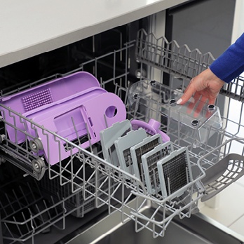 Person placing all Slice ‘n’ Dice’s components in the dishwasher.